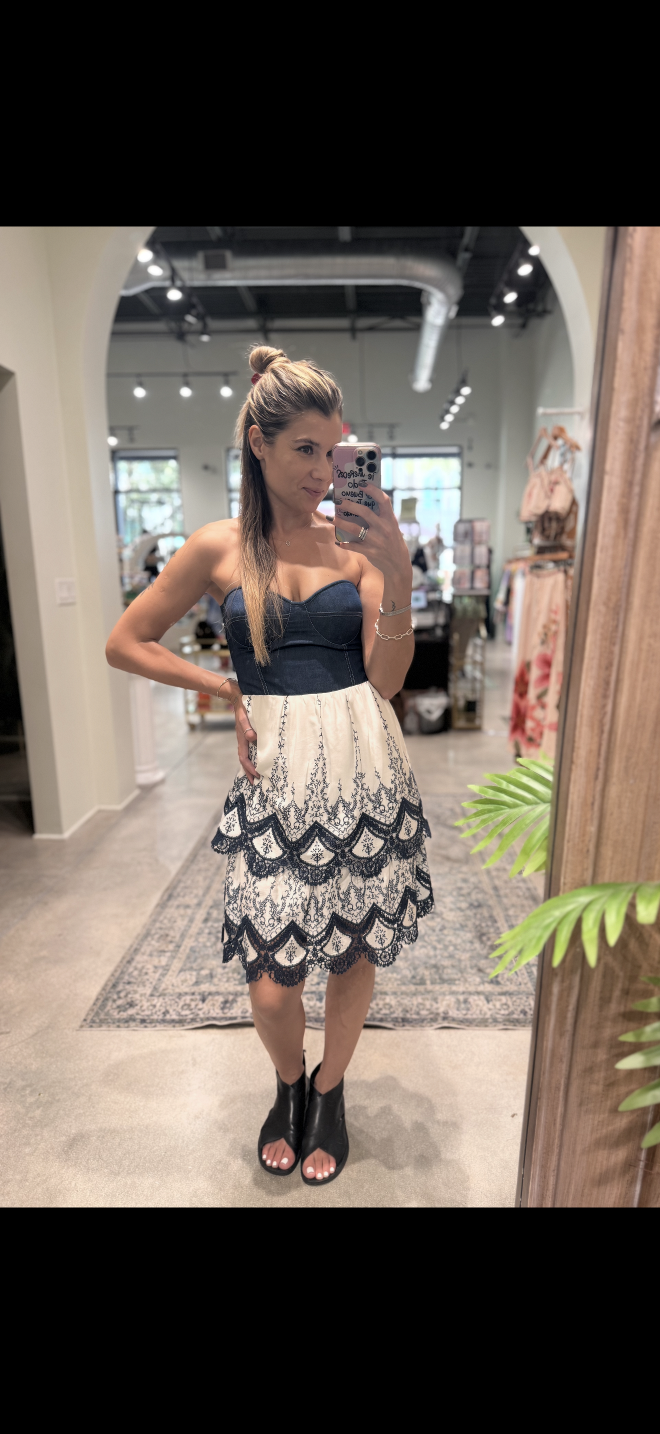 Strapless denim-bodice dress featuring a cream skirt with intricate navy embroidery and scalloped tiers.